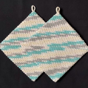 May include: Two crocheted pot holders in a diamond shape with a white, gray, and teal color pattern.