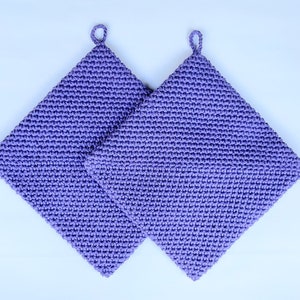 May include: Two purple crocheted pot holders with a loop at the top.