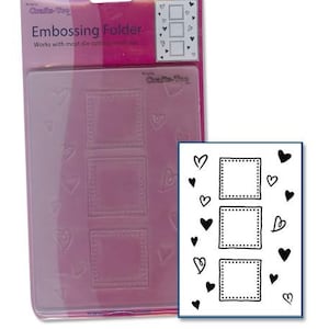 May include: A pink embossing folder with three square frames and heart designs. The packaging includes the text "Embossing Folder" and "Works with most die cutting machines."