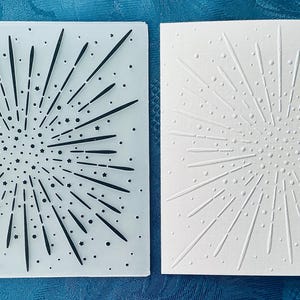 Puede incluir: Una carpeta de relieve cuadrada de plástico translúcido con un patrón de fuegos artificiales con líneas radiantes, puntos y pequeñas estrellas, junto a una hoja de cartulina blanca con el mismo diseño de fuegos artificiales en relieve.