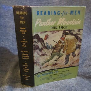 May include: A vintage paperback book cover with a green and white background. The title is "Reading for Men: Panther Mountain" by John Brick. The cover features an illustration of two men hunting in a snowy forest.