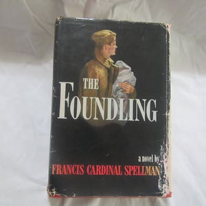 May include: A black hardcover book with the title "The Foundling" in white lettering. The book cover features a black and white illustration of a man in a military uniform holding a baby. The author is listed as "Francis Cardinal Spellman".