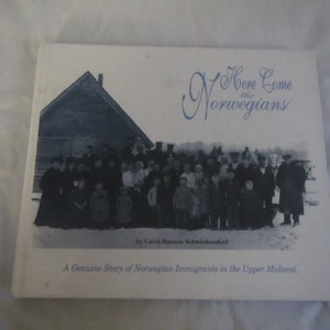 May include: A book cover with a photo of a group of people standing in front of a wooden building. The title of the book is "Here Come the Norwegians" and the subtitle is "A Genuine Story of Norwegian Immigrants in the Upper Midwest".