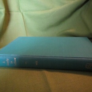 May include: A teal blue hardcover book with the title "A Study in Yellow" printed on the spine.