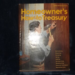 May include: A book titled "Homeowner's How-to Treasury" with a photo of a man hammering a nail into a wooden wall. The book cover lists topics such as remodeling, repairing, plumbing, wiring, lighting, saving energy, woodworking, concrete techniques, and yard and pool care.