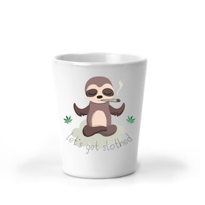 May include: White ceramic mug with a cartoon sloth meditating and smoking a joint. The mug has the text "let's get slothed" printed on it.