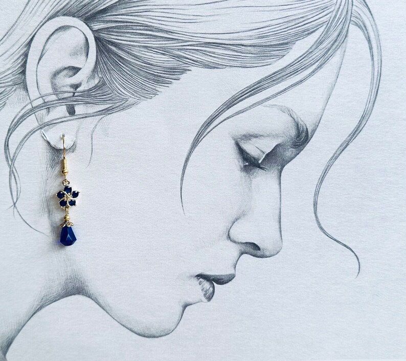 These gorgeous sapphire crystal flower teardrop earrings work well with many different fashion styles and makes a great gift for those born under the September birthstone. 

2  inches
Gold ear wires
Rubber security backs