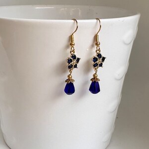 These gorgeous sapphire crystal flower teardrop earrings work well with many different fashion styles and makes a great gift for those born under the September birthstone. 

2  inches
Gold ear wires
Rubber security backs