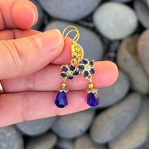 These gorgeous sapphire crystal flower teardrop earrings work well with many different fashion styles and makes a great gift for those born under the September birthstone. 

2  inches
Gold ear wires
Rubber security backs