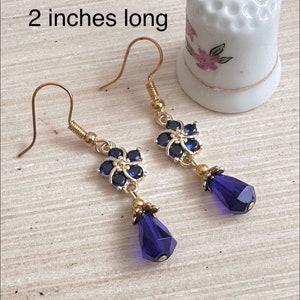 These gorgeous sapphire crystal flower teardrop earrings work well with many different fashion styles and makes a great gift for those born under the September birthstone. 

2  inches
Gold ear wires
Rubber security backs