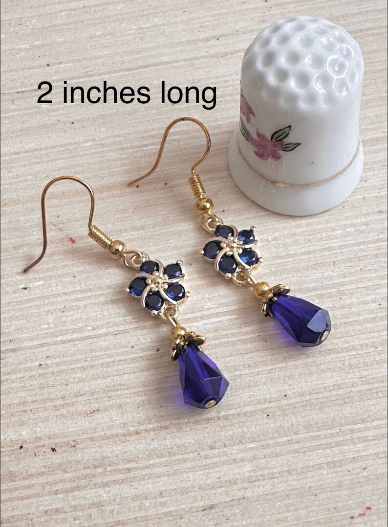 These gorgeous sapphire crystal flower teardrop earrings work well with many different fashion styles and makes a great gift for those born under the September birthstone. 

2  inches
Gold ear wires
Rubber security backs