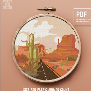 May include: A cross-stitch pattern featuring a desert landscape with a road, cacti, and a mountain in the background. The pattern is framed in a wooden hoop and is labeled "PDF Instant Cross-Stitch Pattern Download". The size of the pattern is 8.68 x 8.68 inches, 22.07 x 22.07 cm, and 139 x 139 stitches. The pattern uses 21 colors and is designed for Aida 16 count fabric.