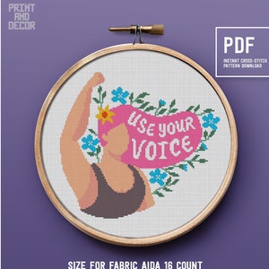 May include: Cross-stitch pattern featuring a woman with her fist raised, surrounded by flowers, with the text "Use your voice". The pattern is for Aida 16 count fabric, 8 inch hoop, and 118 x 108 stitches. It uses 10 colors from the DMC palette.