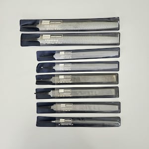 May include: A collection of Craftsman KROMEDGE files in their original packaging. The tools include a 10" wood rasp, half-round file, and 8" mill file. The packaging is black with clear plastic windows.