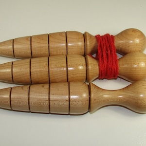 May include: Three wooden watering spikes tied together with red twine. The spikes are designed to deliver water directly to the roots of plants.