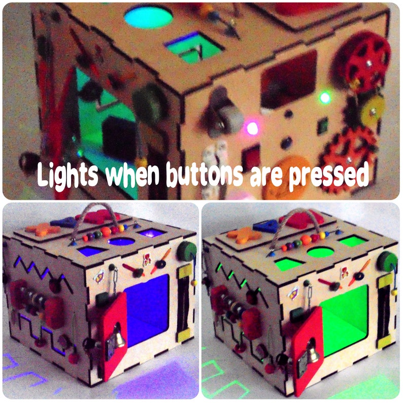 May include: A wooden activity cube with various interactive elements, including buttons that light up when pressed. The cube features a variety of colors, including red, green, blue, and yellow.  The cube is designed for children to explore and learn through play.