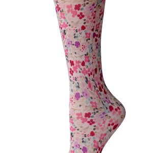 May include: A pair of knee-high socks with a floral pattern in shades of pink, purple, and gray on a beige background.