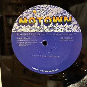 May include: A vinyl record featuring the Motown label with the text "MOTOWN" in gold and a map design. The record label is blue with text that reads "MARVIN GAYE Live At The London Palladium" and "SIDE FOUR".