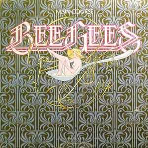 May include: A vintage vinyl record album cover featuring the band "The Bee Gees" with the album title "Main Course" in a gold font. The cover art features a woman in a straw hat sitting in a large silver spoon against a green and gold patterned background.