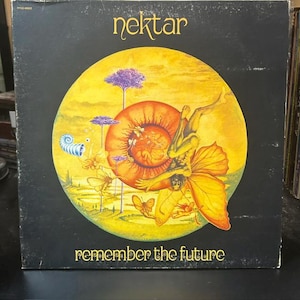 May include: A square vinyl record cover with a black background. The top text reads Nektar and the bottom text reads remember the future. A large yellow circle contains a surreal illustration of a winged figure, butterflies, and trees.