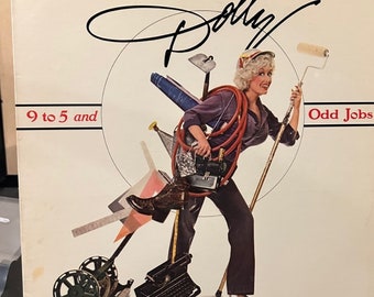 May include: Album cover featuring a woman with blonde hair, wearing a purple shirt and dark pants, carrying various tools and objects. The text reads "Dolly" in a cursive font, with "9 to 5 and Odd Jobs" below.