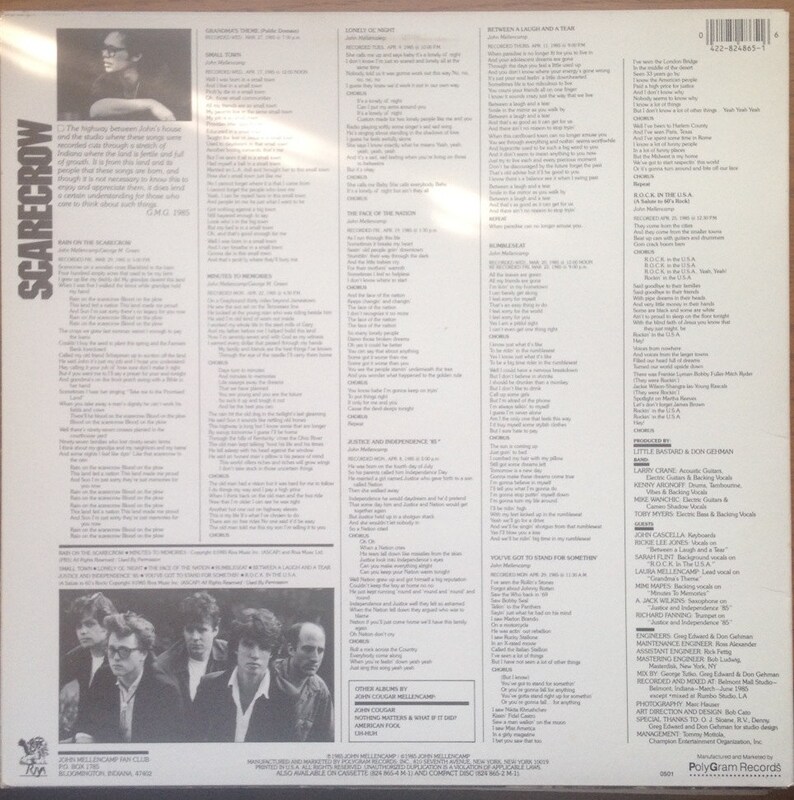 May include: Back cover of a vinyl record album for John Cougar Mellencamp's Scarecrow album. The album cover features a black and white photo of John Cougar Mellencamp with a band. The album cover includes the album title, artist name, and song titles. The album cover also includes the record label, PolyGram Records.