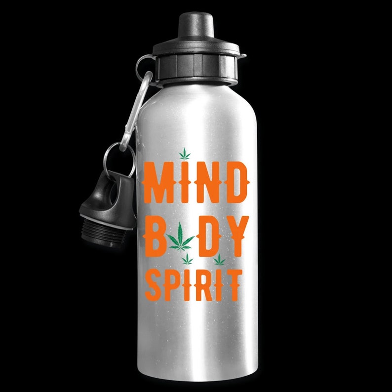 Puede incluir: Botella de agua plateada con tapa negra y un dise&ntilde;o verde y naranja que dice "Mind Body Spirit" con un gr&aacute;fico de hoja de marihuana.