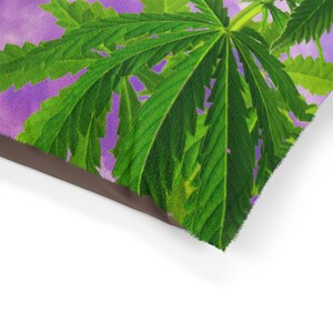 May include: A close-up of a dog bed featuring a purple and green leafy design. The bed is made from a soft, plush material and has a brown border.