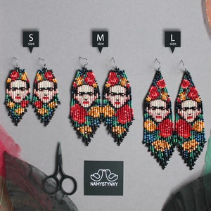 Puede incluir: Tres pares de pendientes de cuentas con un retrato de Frida Kahlo. Los pendientes están disponibles en tres tamaños: pequeño, mediano y grande. Los pendientes están hechos con cuentas de colores y tienen una franja negra.