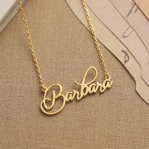 May include: A gold necklace with the name "Barbara" written in a cursive script.