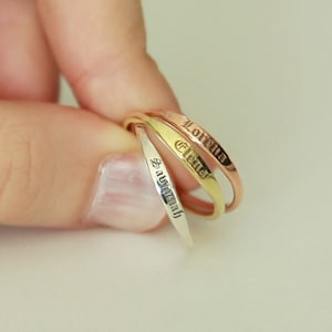 May include: Three thin gold rings with the names "Lorella", "Elena", and "Samantha" engraved on them.