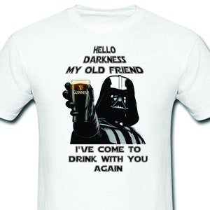 May include: A white t-shirt with a black and white image of Darth Vader holding a glass of Guinness beer. The text "Hello Darkness My Old Friend" is above the image and the text "I've come to drink with you again" is below the image.