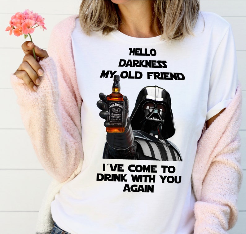 May include: White t-shirt with a black and white image of Darth Vader holding a bottle of Jack Daniel's whiskey. The text "Hello Darkness My Old Friend I've Come To Drink With You Again" is printed on the shirt.