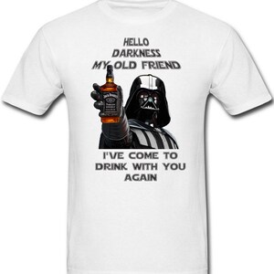 May include: White t-shirt with a black and white image of Darth Vader holding a bottle of Jack Daniel's whiskey. The text "Hello darkness my old friend" and "I've come to drink with you again" is printed on the shirt.