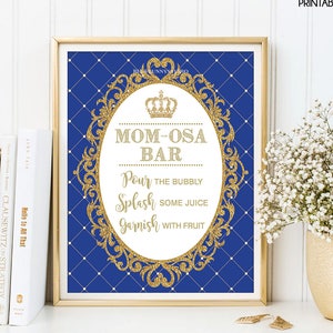May include: A printable sign for a royal themed party. The sign is blue with a gold frame and a crown. The text on the sign reads "Mom-osa Bar" and "Pour the bubbly, Splash some juice, Garnish with fruit".