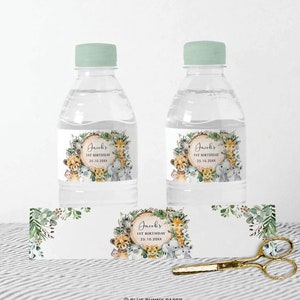 May include: Water bottle labels with a jungle animal theme. The labels feature a wreath of green leaves and a circle with the text "Jacob's 1st Birthday 25.10.20XX". There are illustrations of a lion, giraffe, elephant, monkey, and zebra.