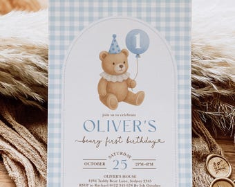 May include: A blue and white checked birthday invitation. The card features a teddy bear illustration holding a number one balloon. The text reads "Oliver's beary first birthday". The event is on October 25th.