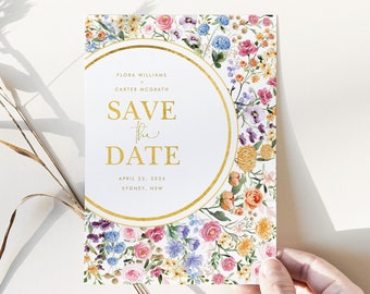 May include: A white save the date card with a gold circle border and floral design. The text reads "Flora Williams & Carter McGrath Save the Date April 25, 2024 Sydney, NSW".