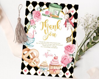 May include: Alice in Wonderland themed thank you card with a black and white checkered background. The card features a pink flamingo, a white rabbit, a Mad Hatter's hat, and a key. The text on the card reads "Thank You" and "I loved the cake and presents too, But my most favorite part was seeing you! Thank you for making my 1st birthday wonderful. love, Alicia."