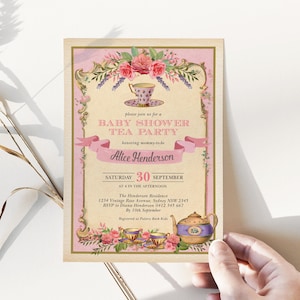 May include: A pink and gold baby shower invitation with a teacup and teapot design. The invitation reads "Please join us for a Baby Shower Tea Party honouring mummy-to-be Alice Henderson. Saturday, 30th September at 4 in the afternoon. The Henderson Residence, 1234 Vintage Rose Avenue, Sydney NSW 2345. RSVP to Diana Henderson 0412 345 667 by 10th September. Registered at Pottery Bark Kids."