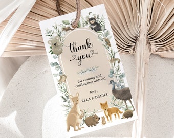 Può includere: Biglietto di ringraziamento con sfondo marrone e bordo bianco. Il biglietto presenta una varietà di animali australiani, tra cui un koala, un canguro, un echidna e un emu. Il testo sul biglietto dice "grazie" con un simbolo di cuore e "per essere venuto e aver festeggiato con noi! con affetto, ELLA & DANIEL."