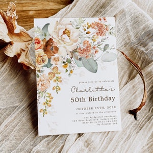 May include: A floral invitation card for a 50th birthday celebration. The card features a watercolor design of cream, orange, and brown flowers with green foliage. The text reads "Charlotte's 50th Birthday" with event details.