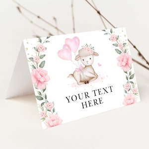 Op de afbeelding: Een witte kaart met een roze bloemrand en een schattig cartoonlam dat roze hartballonnen vasthoudt. De tekst "YOUR TEXT HERE" staat op de kaart gedrukt.
