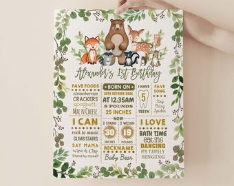 May include: A woodland-themed first birthday poster with a green and brown color scheme. The poster features a bear, fox, deer, owl, raccoon, and skunk. The poster includes the child's name, Alexander, and details about their first year, including their birthdate, weight, height, and favorite foods. The poster also includes a list of things the child can do, such as rock to music, climb stairs, and say mama. The poster is decorated with green leaves and flowers.