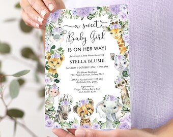May include: A purple and green baby shower invitation with a watercolor illustration of a giraffe, lion, elephant, zebra, cheetah, and monkey. The text reads "a sweet Baby Girl is on her way!" and includes the name Stella Blume, the date and time of the shower, and the location.