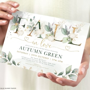 May include: Fall in love bridal shower invitation with a watercolor background featuring green leaves, white pumpkins, and gold lettering. The invitation reads "Fall in love" and "Autumn Green" with the date and time of the event. The invitation also includes the address and RSVP information.