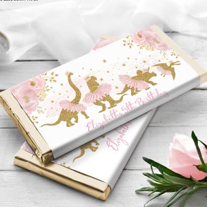 May include: Pink and gold chocolate bar wrappers with a floral design and a silhouette of a dinosaur wearing a tutu. The text "Elizabeth's 5th Birthday" is printed on the wrapper.