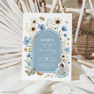 Peut inclure: Une invitation florale bleue et blanche pour un premier anniversaire. L'invitation présente une illustration aquarelle de fleurs et une fée. Le texte sur l'invitation indique "Elfie's fairy 1st birthday" et comprend la date, l'heure et le lieu de la fête.