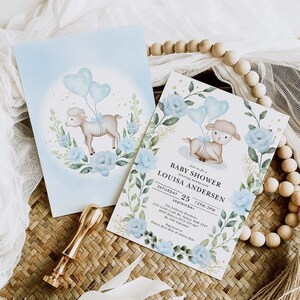 May include: A baby shower invitation with a blue and white watercolor design featuring a lamb holding blue heart balloons. The text on the invitation reads "Join us for a Baby Shower honoring mommy-to-be Louisa Andersen Saturday 25 September 12PM-2PM".