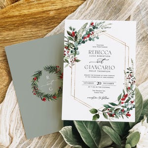 Può includere: Invito di nozze con design botanico. L'invito presenta i nomi di Rebecca e Giancarlo, con la data del 20 dicembre. Il design include una cornice geometrica dorata e una ghirlanda di verde e bacche rosse.